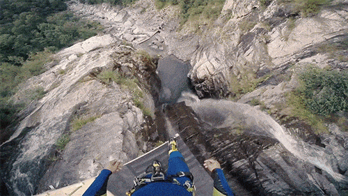 Mann springt von Berg in eine Schlucht ins Wasser